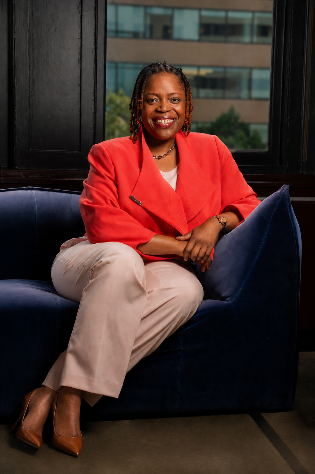 Janelle Renee Jenkins seated in a coral jacket